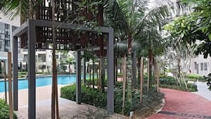 A pool area with a red pathway, surrounded by greenery and modern architecture.