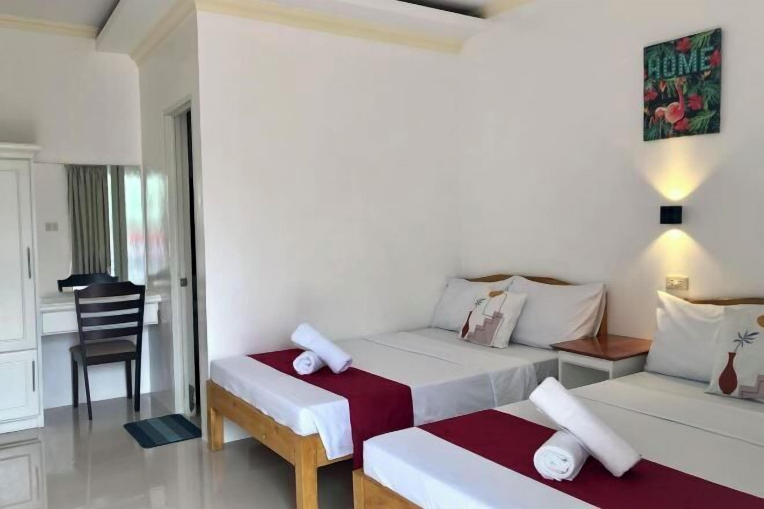 Una habitación de hotel con dos camas individuales, un escritorio y una silla.