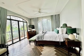 Une chambre d’hôtel équipée d’un lit, d’une télévision, d’un bureau et offrant une vue sur l’extérieur.