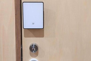 A door with a modern lock and a control panel above it. - SEN.RETREAT TAKAHARA (Tanabe)