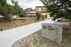 A concrete pathway leading to a building with a sign that reads 'Zen Retreat.' - SEN.RETREAT TAKAHARA (Tanabe)