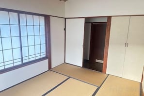 A traditional Japanese room with tatami flooring, sliding doors, and a wardrobe. - Yuzawa Ishiuchi Maruyama Nozomi Ryokan (Minamiuonuma)