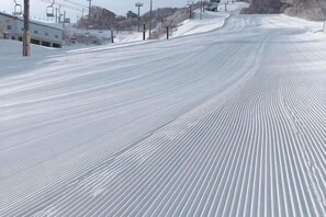 Une piste de ski enneigée, avec des remontées mécaniques et des bâtiments en arrière-plan.