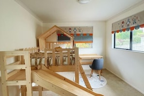 A child's bedroom with a bunk bed, a desk, and a chair. - 5 Bed Panoramic Sea & Town View (Oamaru)