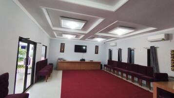 A conference room with a red carpet, a long table, and chairs arranged around it.