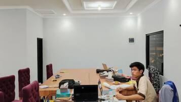 A conference room with a long table, chairs, and a laptop.