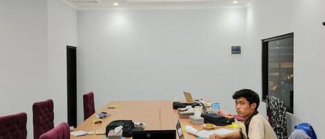 A conference room with a long table, chairs, and a laptop.