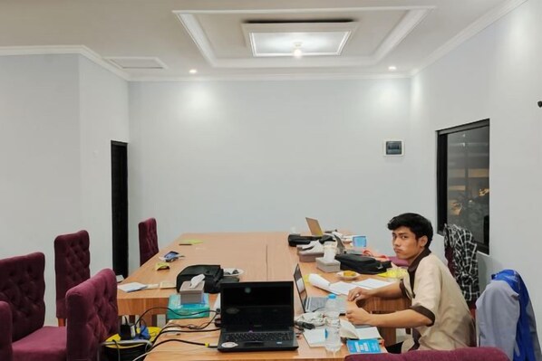 A conference room with a long table, chairs, and a laptop. - HOTEL CIWANGI (Bungursari)