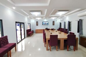 A conference room with a long table, chairs, and a television screen. - HOTEL CIWANGI (Bungursari)