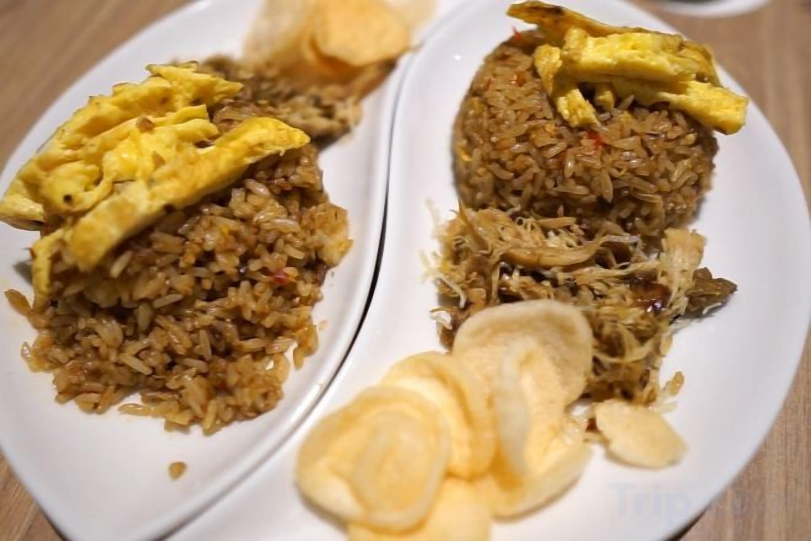 A plate of fried rice with scrambled eggs and sliced almonds.
