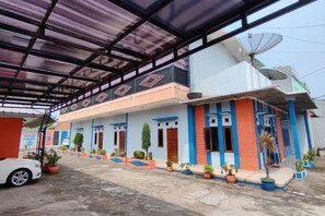 A building with a covered entrance, satellite dish, and potted plants. - HOTEL CIWANGI (Bungursari)
