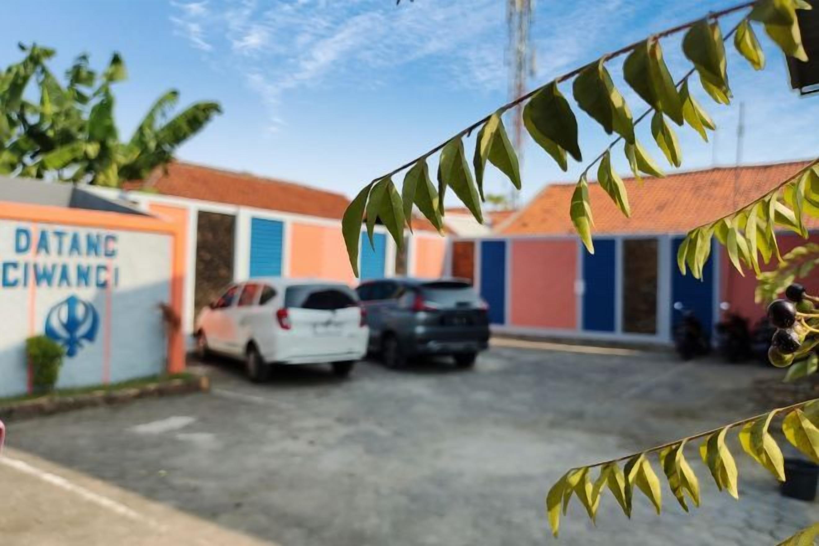 A parking area with a building labeled 'DATANG CIWANGI' and a clear sky.