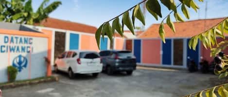 A parking area with a building labeled 'DATANG CIWANGI' and a clear sky.