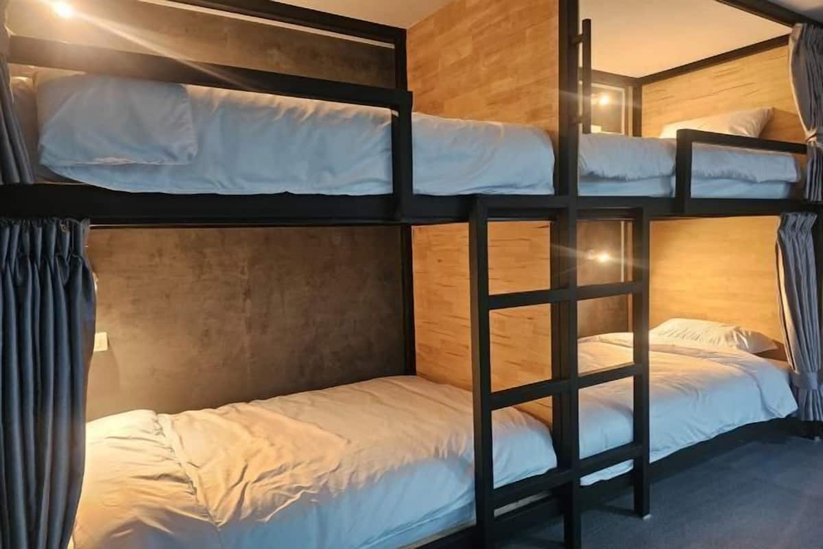 A bunk bed room with a wooden wall and curtains.