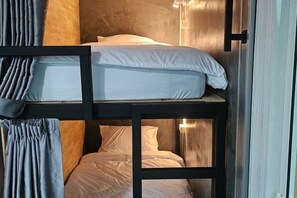 A bunk bed with white bedding and a wooden headboard. - The Bird Nest Homestay& Coffee Shop (Phra Pradaeng)
