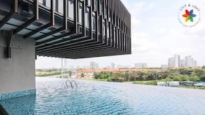 Una piscina infinita con vista a la ciudad, diseño arquitectónico moderno y un logotipo en la esquina.