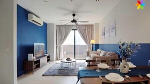 Una sala de estar moderna con comedor, ventilador de techo y un amplio ventanal con cortinas.