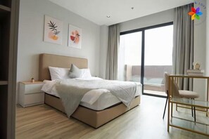 Una habitación de hotel moderna con una cama, una mesita de noche y vistas al exterior.