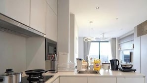 Una cocina moderna con armarios blancos, una estufa y un lavamanos.