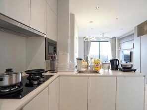 Une cuisine moderne avec des meubles blancs, une cuisinière et un évier.