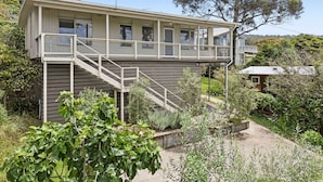 A two-story house with a balcony, surrounded by greenery and a tree. - Prasino in Central Lorne (Lorne)