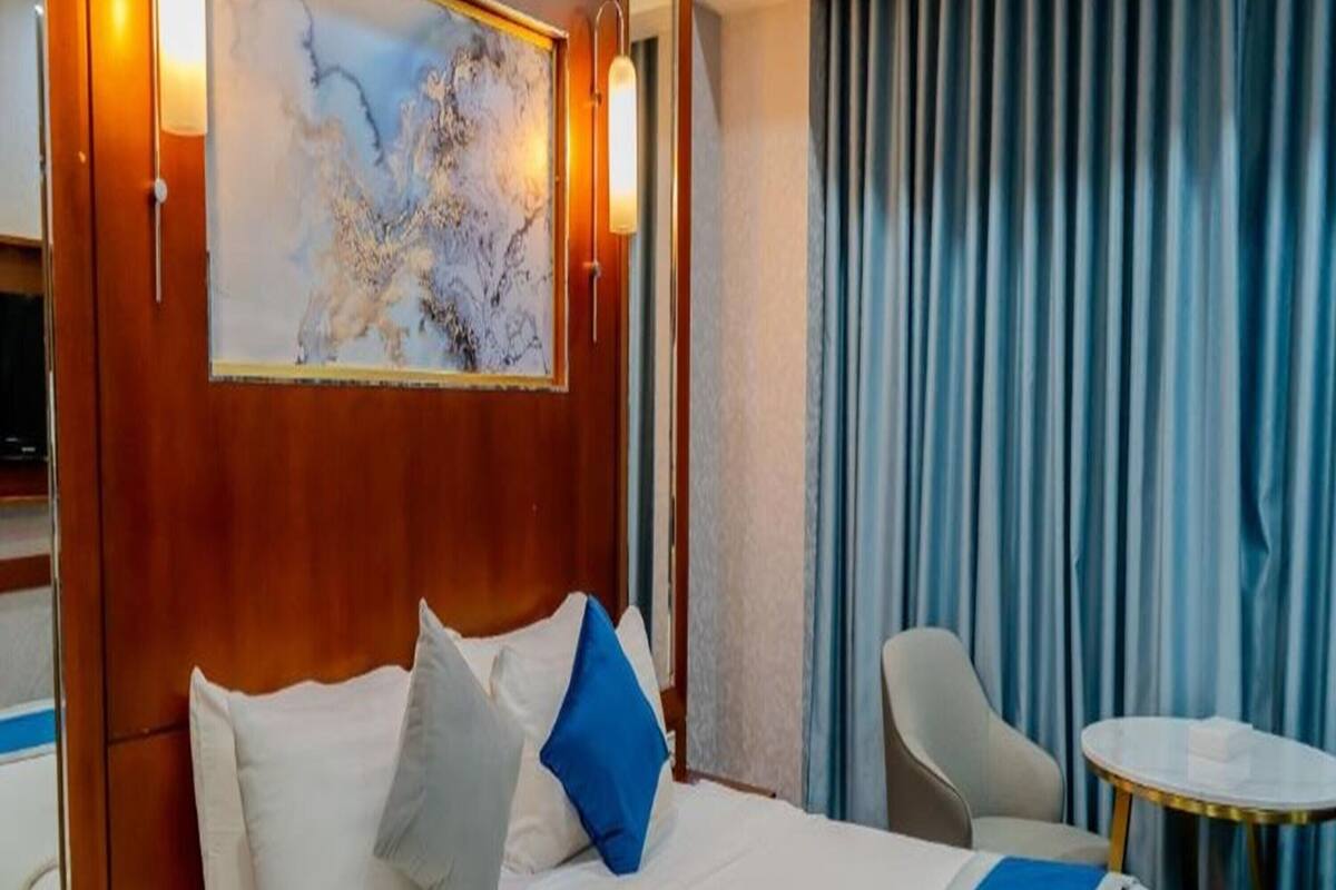 Une chambre d’hôtel avec un grand lit, un bureau, une chaise et une petite table.