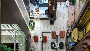A spacious atrium with a central seating area featuring multiple sofas and tables, surrounded by glass railings and a marble floor. - Dancenter Al Dabab Near King Fahad Medical City (Riyadh)