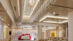 A spacious lobby with a central reflective floor, modern sofas, and a decorative red floral arrangement. - Dancenter Al Dabab Near King Fahad Medical City (Riyadh)