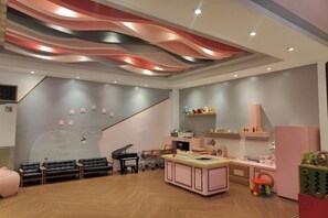 A children's playroom with a piano, seating area, and play tables. - The Mark Resort Cebu (Lapu-Lapu City)