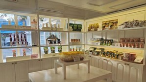 A store with shelves stocked with various packaged goods, a table in the center, and a view of the outside through the windows. - The Mark Resort Cebu (Lapu-Lapu City)