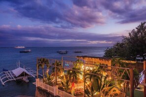 A waterfront property with a pool area, a sign reading 'Cove Resort,' and boats in the water. - The Mark Resort Cebu (Lapu-Lapu City)