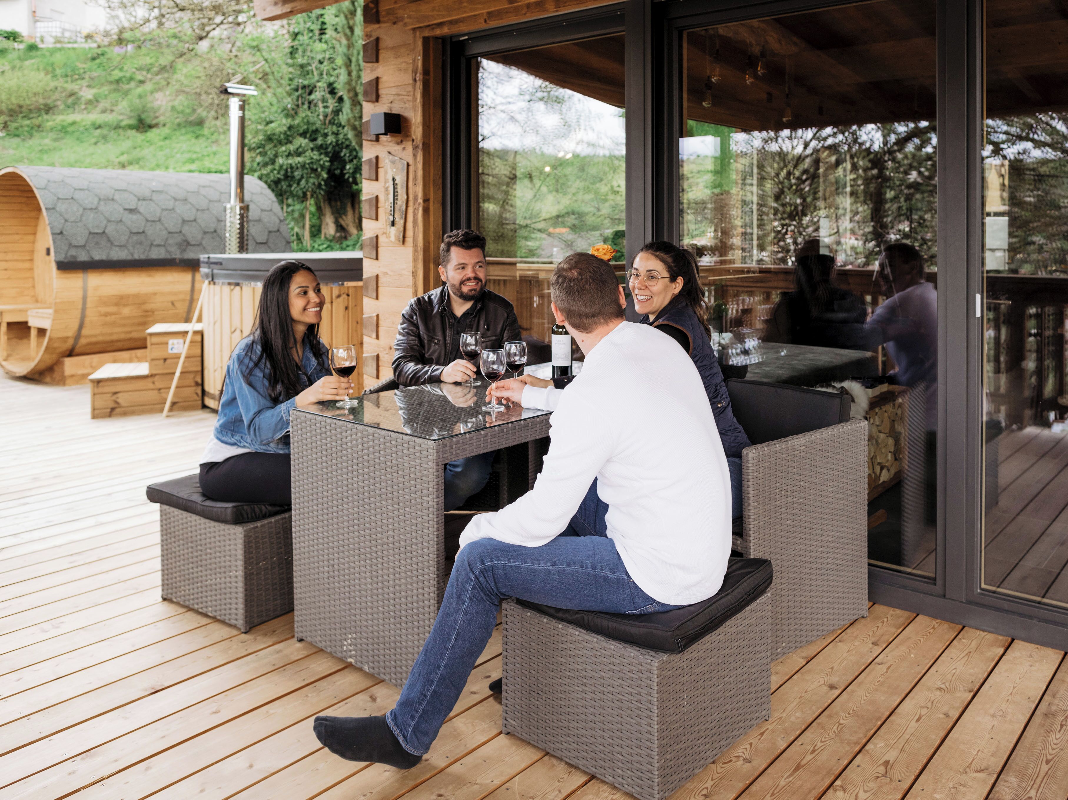 A covered outdoor seating area with wicker furniture and a view of the outdoors.