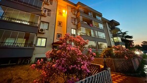 A multi-story residential building with balconies, air conditioning units, and a well-lit entrance. - ÜNYE KAVAKLAR GÜNLÜK EV (Ünye)