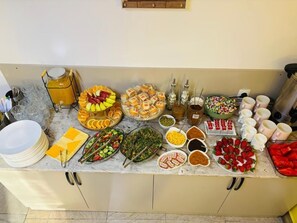 A buffet setup with various food items and condiments. - Styopa Hotel (Yerevan)