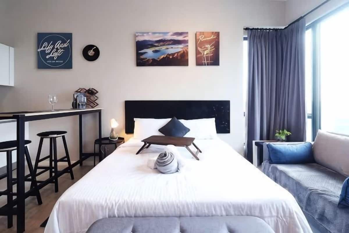 Une chambre d’hôtel avec un lit, un bureau, une chaise et une fenêtre avec des rideaux.