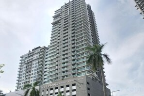 A high-rise building with multiple balconies, a prominent sign at the base, and a clear sky in the background. - Lily & Loft - The Grand Sofo, Petaling Jaya (Petaling Jaya)