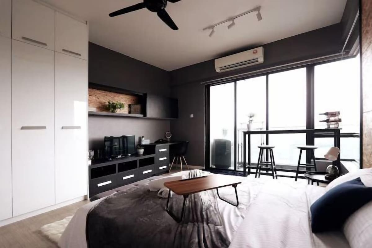 Ein modernes Schlafzimmer mit Bett, Schreibtisch, Deckenventilator und großem Fenster.
