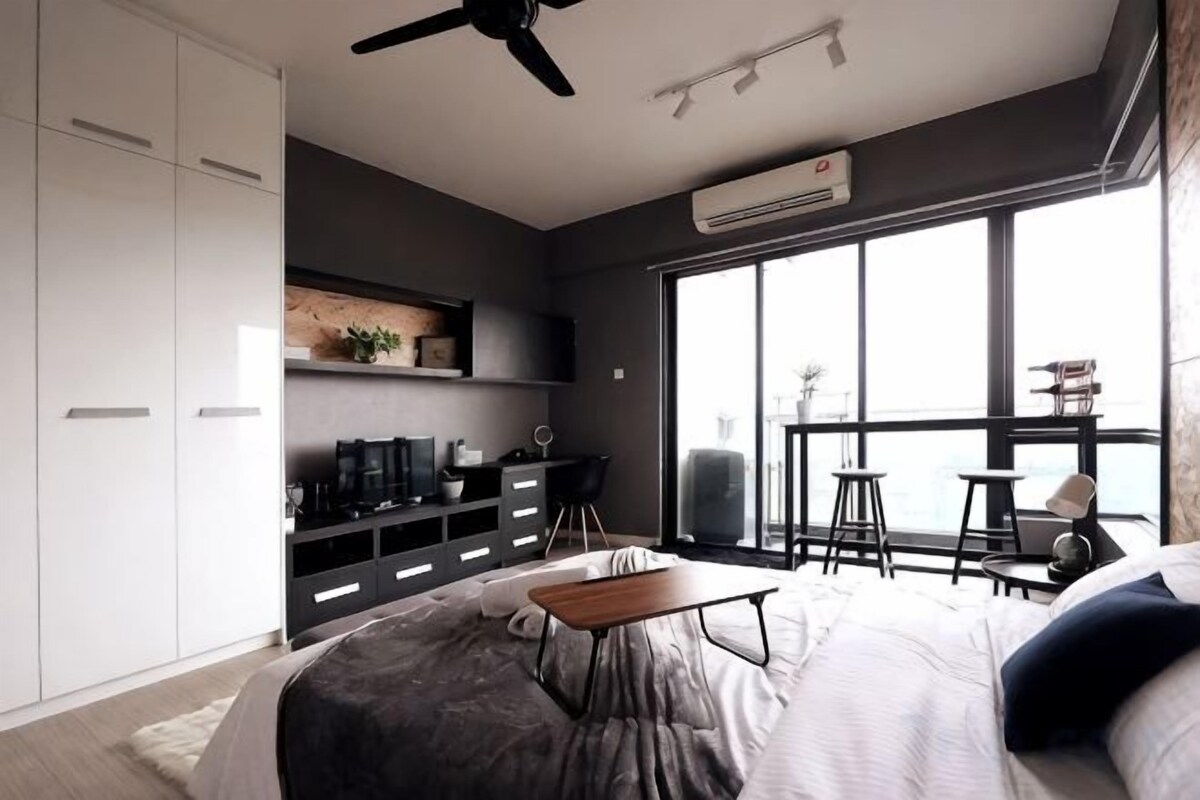 Ein modernes Schlafzimmer mit Bett, Schreibtisch und Balkon mit Blick.