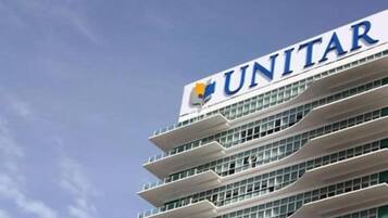 A multi-story building with the UNITAR logo on the top.