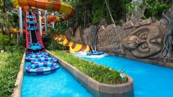 A water park with a water slide, inflatable rafts, and a mural.