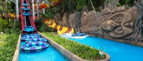 A water park with a water slide, inflatable rafts, and a mural.