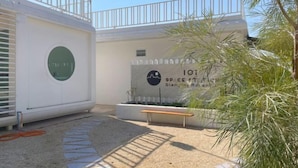 A building with a white exterior, a circular window, and a sign reading "101 SPACE ST." - 101 Space Station (Lan Sak)