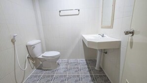 A small, clean bathroom with a toilet, sink, and shower. - Sleepdive Samaesan (Sattahip)