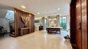Un interior moderno con comedor, paneles de madera y una escalera.
