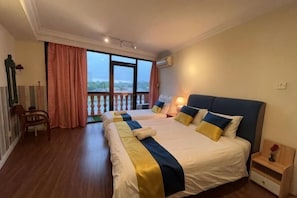 Une chambre avec un grand lit, un balcon, une chaise et une table de chevet avec une lampe.