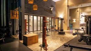 A gym with exercise equipment, a wooden bench, and a patterned wall. - Mulberry Verve Suites KL Mid Valley 4Pax 2 Bedroom (Kuala Lumpur)