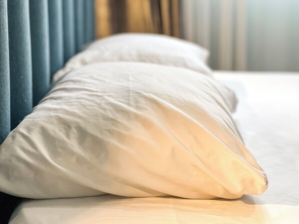 A bed with white pillows and a blue headboard. - Hotel Tier Center (Tirana)