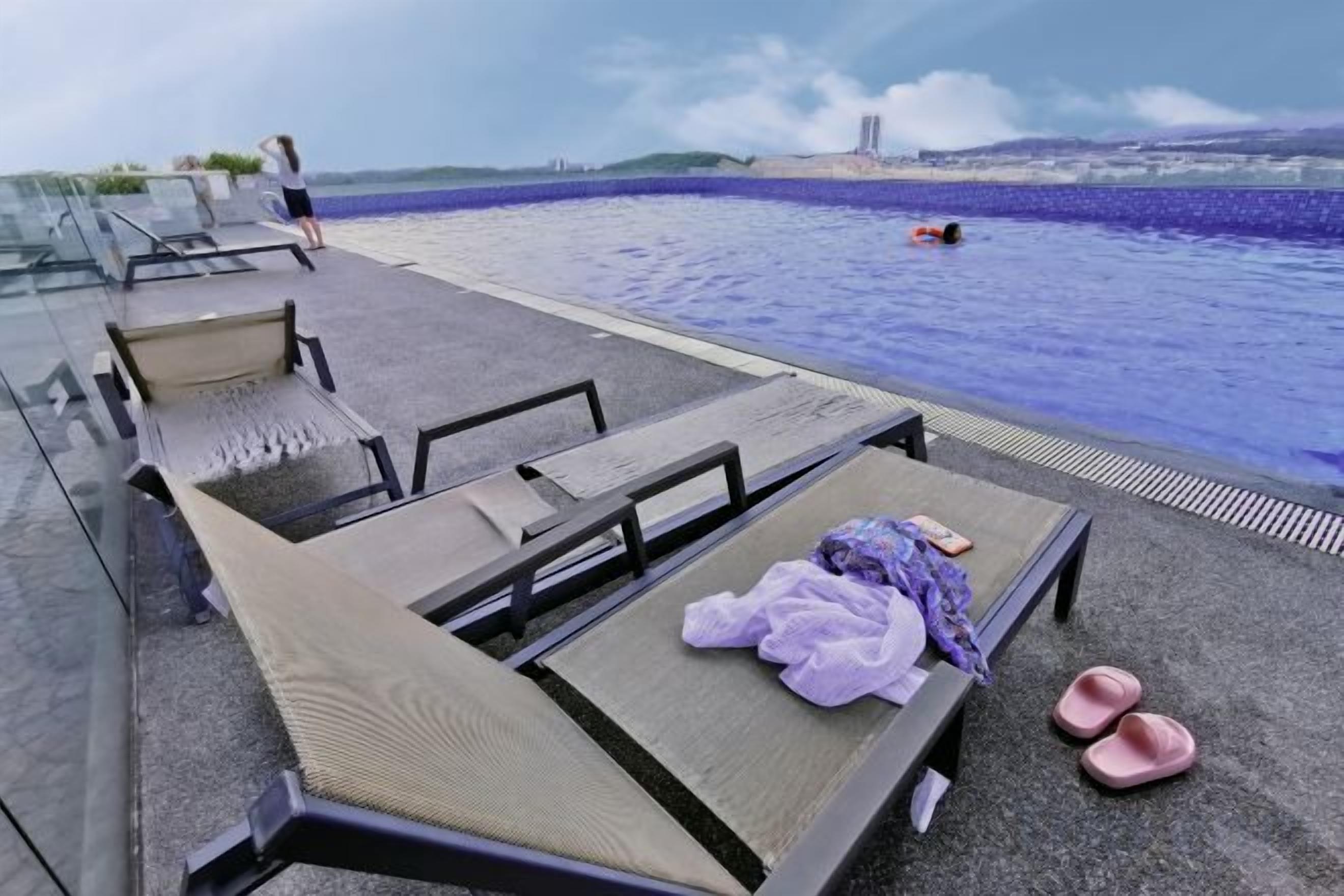 A poolside area with lounge chairs and a pool.