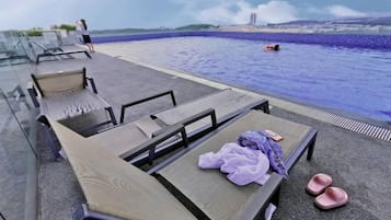 A poolside area with lounge chairs and a pool.