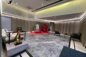 A hotel lobby with a reception desk, seating area, and a red carpet leading to a reception desk. - Agile SkyView Suites KL (Kuala Lumpur)